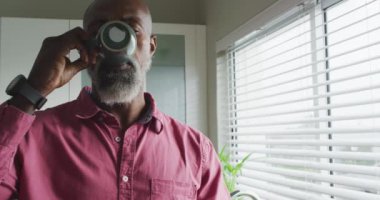 Afro-Amerikan bir adamın mutfakta kahve içişini gösteren bir video. Boş zaman, rahatla ve ev kavramında zaman geçir..