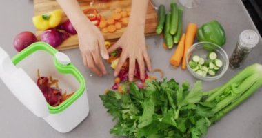 Video of midsection of asian woman putting peels in bin. Lifestyle and spending time at home concept.