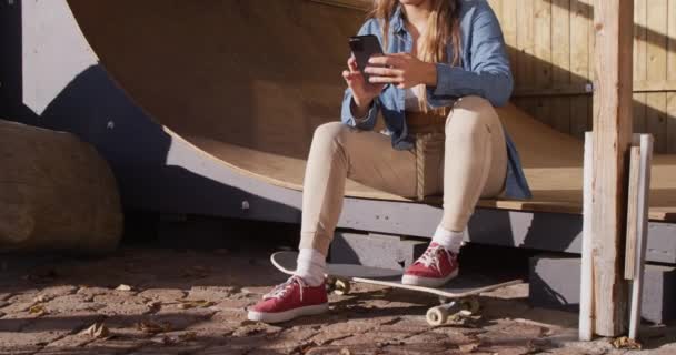 Video Happy Caucasian Female Skateboarder Resting Using Smartphone Skateboarding Sport — 图库视频影像