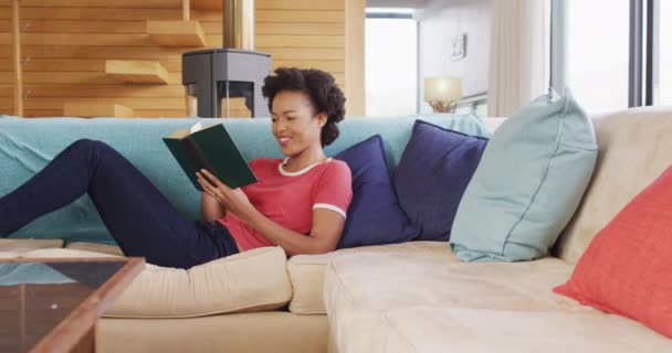 Video African American Woman Reading Book Sofa Lifestyle Spending Time — ストック動画