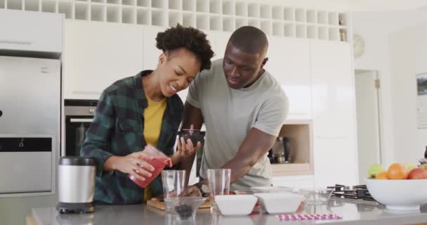 Видео Счастливая Африканская Пара Готовит Сок Вместе Кухне Любовь Отношения — стоковое видео