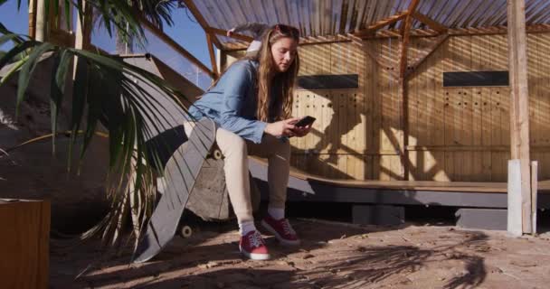 Βίντεο Χαρούμενη Καυκάσια Γυναίκα Skateboarder Ανάπαυση Και Χρήση Smartphone Skateboarding — Αρχείο Βίντεο