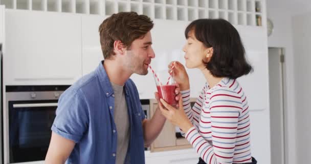 Video Happy Diverse Couple Drinking Juice Straws Kitchen Love Relationship — Stockvideo