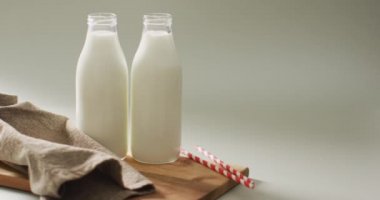 Video of glass bottles of milk on white background. dairy products and healthy organic nutrition.