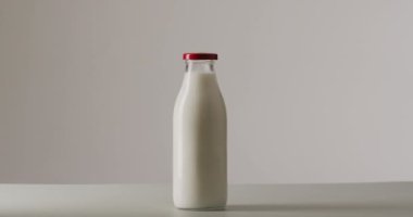 Video of glass bottles of milk on white background. dairy products and healthy organic nutrition.