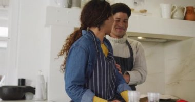 Video of happy biracial couple preparing meal together. Domestic lifestyle and leisure time at home.