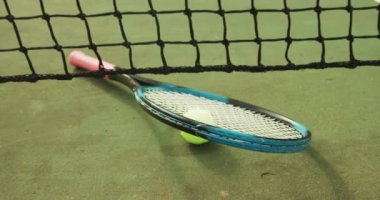 Video of tennis racket and tennis ball on the green court. Healthy active lifestyle and tennis.
