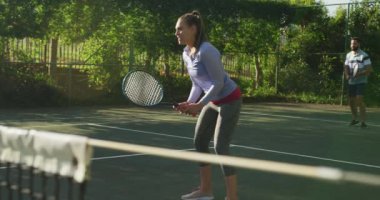 Video of happy caucasian couple playing tennis on the court. Healthy active lifestyle and fitness at home.