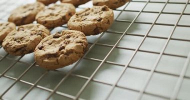 Video of rows biscuits on a baking rack over white background. cookies,bake, food, candy, snacks and sweets concept.