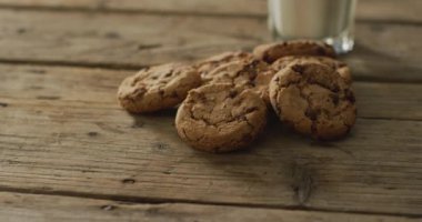 Video of biscuits with chocolate and milk on wooden background. cookies,bake, food, candy, snacks and sweets concept.