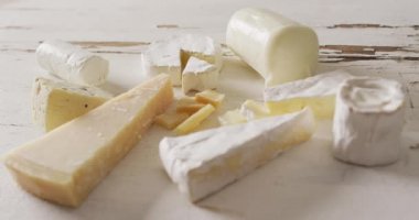 Video of assorted hard and soft cheeses on rustic white wooden table top. quality, tasty light food snack.