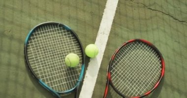 Video of tennis racket and tennis ball on the green court. Healthy active lifestyle and tennis.