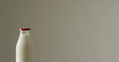 Video of glass bottles of milk on white background. dairy products and healthy organic nutrition.