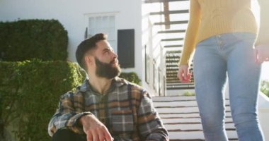 Video of happy caucasian warmly dressed couple spending time in the garden. Domestic lifestyle and leisure time in the garden.