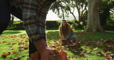 Video of happy caucasian warmly dressed couple having fun in the garden. Domestic lifestyle and leisure time in the garden.