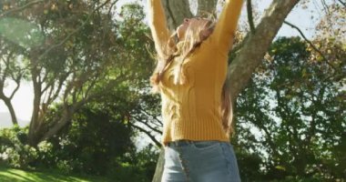 Video of happy caucasian warmly woman dressed spending in the garden. Domestic lifestyle and leisure time in the garden.