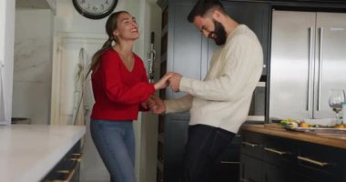 Video of happy caucasian couple peeling vegetables in the kitchen. Domestic lifestyle and leisure at home.