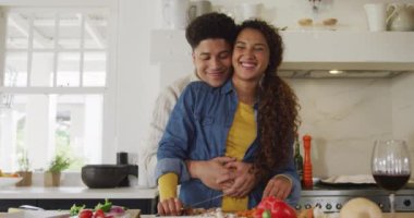 Video of happy biracial couple preparing meal together. Domestic lifestyle and leisure time at home.
