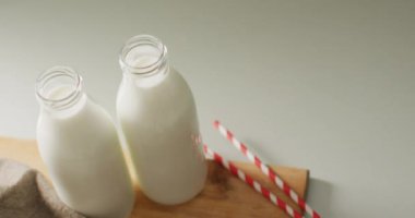 Video of glass bottles of milk on white background. dairy products and healthy organic nutrition.
