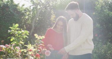 Video of happy caucasian couple spending time in the garden. Domestic lifestyle and leisure at home.