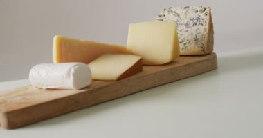 Video of assorted hard and soft cheeses on wooden chopping board. quality, tasty light food snack.