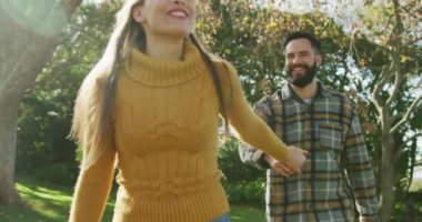 Video of happy caucasian warmly dressed spending couple in the garden. Domestic lifestyle and leisure time in the garden.