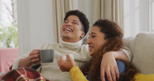 Video Happy Biracial Couple Siting Sofa Blanket Drinking Coffee Domestic — Video Stock