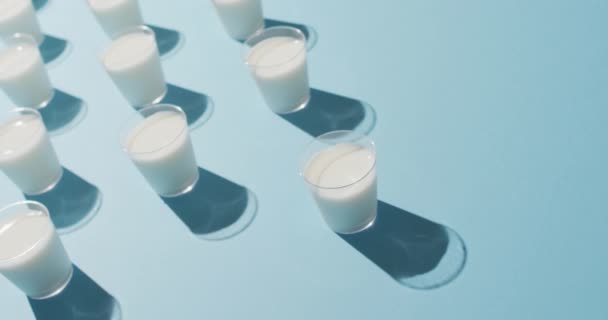 Βίντεο Από Μια Σειρά Από Ποτήρια Γάλα Μπλε Φόντο Γαλακτοκομικά — Αρχείο Βίντεο