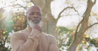 Düşünceli yaşlı Afrikalı Amerikalı adamın bahçede tefekkür ettiği bir video. Emeklilik, ev hayatı, kapsayıcılık, sağlık ve mutluluk kavramı dijital olarak oluşturulmuş video.