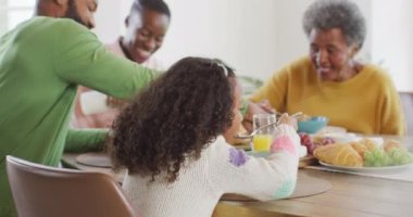 Afro-Amerikan ebeveynlerin, kız çocuklarının ve büyükbabalarının yemek masasında yemek yediği video. Aile, aile hayatı ve birliktelik kavramı dijital olarak oluşturulmuş video.