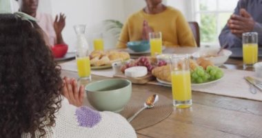 Afro-Amerikan ailelerin, kız çocuklarının ve büyükbabalarının yemek masasında dua ettikleri videolar. Aile, aile hayatı ve birliktelik kavramı dijital olarak oluşturulmuş video.