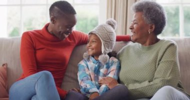 Oturma odasında oturan gülümseyen Afrikalı Amerikalı anne, kız ve büyükannenin video portresi. Aile, aile hayatı ve birliktelik kavramı dijital olarak oluşturulmuş video.