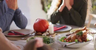 Video of happy caucasian daughter and senior father saying grace at table before family meal. Family, domestic life and togetherness concept digitally generated video.