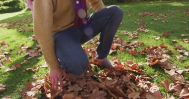 Video of happy caucasian father piggybacking daughter in sunny autumn garden. Family, domestic life and togetherness concept digitally generated video.