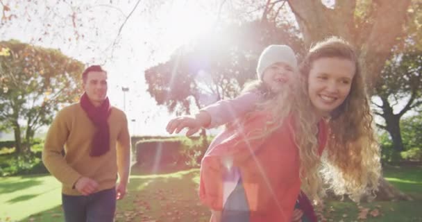 Video Happy Caucasian Parents Smiling Mother Piggybacking Daughter Sunny Autumn — Video