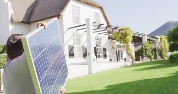 Video Caucasian Man Carrying Solar Panel Sunny Garden Domestic Life — стоковое видео