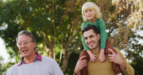 Video Smiling Caucasian Father Carrying Son Shoulders Walking Grandfather Garden — Video