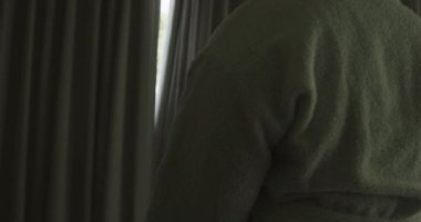 Mutlu Afro-Amerikan kadın bornoz giyiyor, perdeleri açıyor ve pencereden bakıyor. ev hayatı, evde boş vakitlerin tadını çıkarmak..