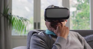 VR kulaklık takan ve evde eğlenen son sınıf öğrencisi mutlu. emeklilik hayatı teknolojiyle evde dinleniyor..