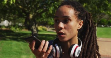 Akıllı telefondan konuşan Afrikalı Amerikalı kadını yakından çek. dijital göçebe yaz yaşam tarzı devam ediyor.