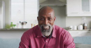 Mutlu Afro-Amerikan bir adamın video görüntüsü. Rahatlayın, rahatlayın ve teknoloji konseptiyle evde vakit geçirin..
