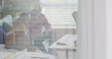 Afrikalı Amerikalı baba ve oğlunun evdeki kanepede konuştuğu bir video. Aile, evde birlikte vakit geçirmek..