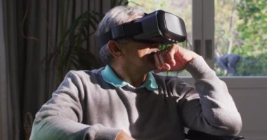 VR kulaklık takan ve evde eğlenen son sınıf öğrencisi mutlu. emeklilik hayatı teknolojiyle evde dinleniyor..