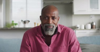 Mutlu Afro-Amerikan bir adamın video görüntüsü. Rahatlayın, rahatlayın ve teknoloji konseptiyle evde vakit geçirin..