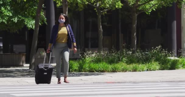 戴口罩的非裔美国女人背着手提箱穿过马路 科罗纳韦病毒 Coronavirus Covid 大流行期间 — 图库视频影像