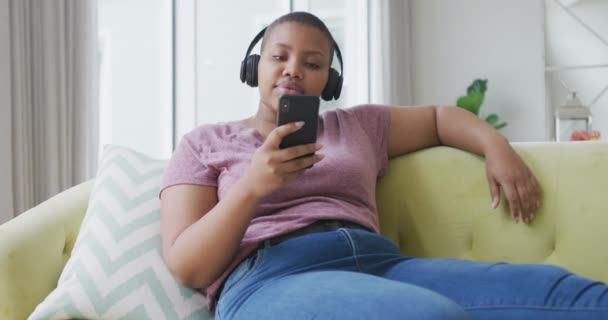 Feliz Afroamericano Más Mujer Tamaño Sentado Sofá Con Auriculares Uso — Vídeo de stock