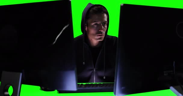 Een Blanke Hacker Een Zwarte Kap Met Twee Computers Groen — Stockvideo