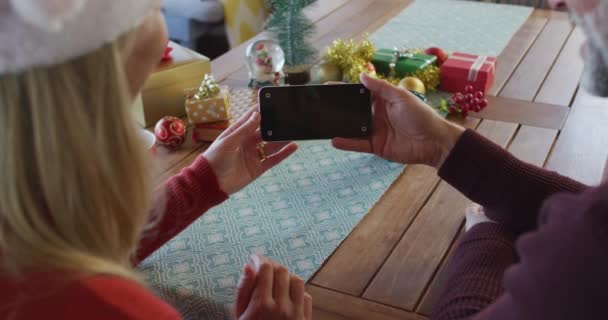 Szczęśliwy Kaukaski Dojrzały Para Noszenie Santa Kapelusze Pomocą Smartfona Miejsca — Wideo stockowe
