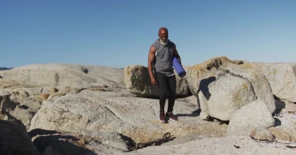 Homem Afro Americano Sênior Exercitando Andando Sobre Rochas Beira Mar — Vídeo de Stock