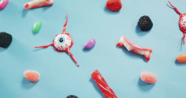 Close Zicht Meerdere Halloween Speelgoed Snoepjes Tegen Een Blauwe Achtergrond — Stockvideo
